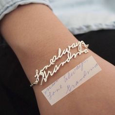 a person wearing a bracelet with writing on it and a name tag attached to the wrist