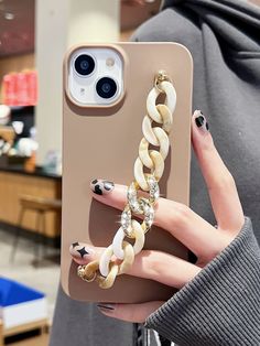 a woman holding up her phone case with rings on it