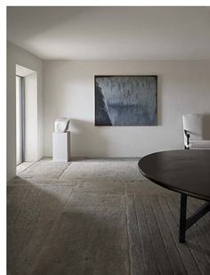 a living room with white walls and wood flooring is pictured in this image, there are two lamps on either side of the coffee table