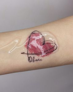 a person's arm with a tattoo on it that has a heart in the center