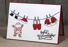 a handmade christmas card with clothes hanging on a line and santa's hat