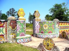 several colorfully painted sculptures in the middle of a field