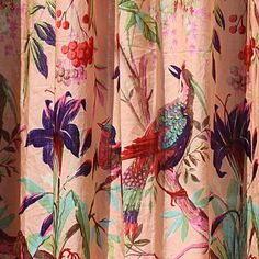 the curtain is decorated with colorful flowers and birds on pink fabric, along with red berries