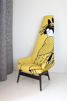 a yellow chair sitting in front of a curtain