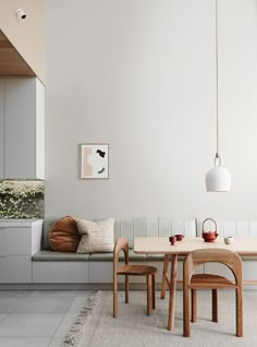 a dining room table with chairs and a bench in front of the wall next to it