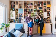 a family standing in front of a bookshelf