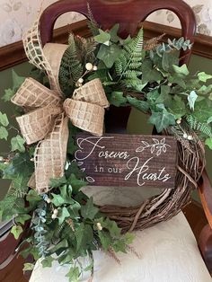 a wooden sign sitting on top of a chair covered in green leaves and greenery