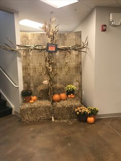 a cross made out of hay and pumpkins