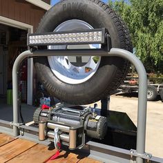 a truck with a tire mounted to the back of it's flatbed trailer