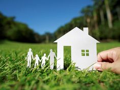 a paper cutout of a family standing in front of a house on the grass stock photo