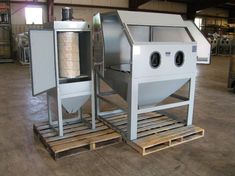 two machines sitting on pallets in a warehouse