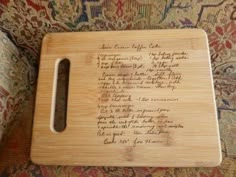 a cutting board with writing on it sitting on top of a couch next to a rug