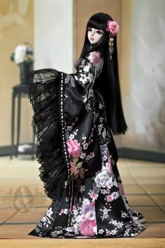 a doll with long black hair wearing a dress