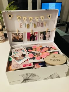 an open birthday box with photos and decorations