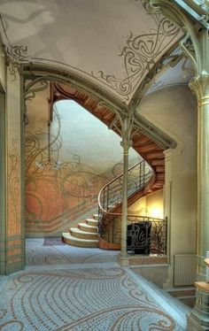 an ornately decorated hallway with stairs and carpeted flooring is seen in this image