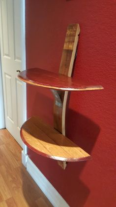 a wooden surfboard is mounted to the side of a red wall in a room