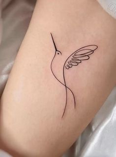 a small hummingbird tattoo on the thigh