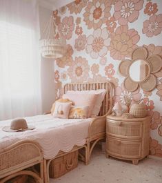 a bedroom with floral wallpaper and wicker furniture