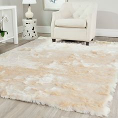 a living room with a white chair and rug