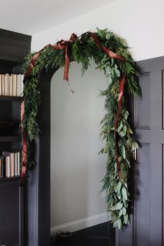 a christmas wreath is hanging on the wall in front of a bookcase with books