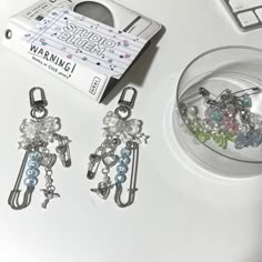 several charms sitting on top of a white table next to a package of tape measure