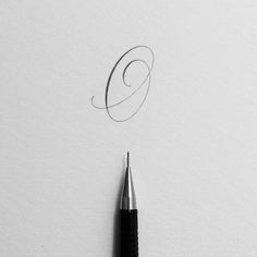 a pen is laying on top of a piece of paper with the letter c in it