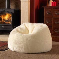 a white bean bag chair sitting in front of a fire place with a wood burning stove