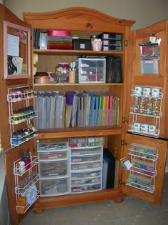 an open bookcase filled with lots of books and crafting supplies on top of a tile floor