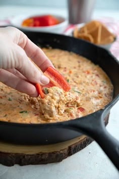 a person is dipping some food into a skillet