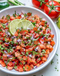 a white bowl filled with chopped up vegetables and garnished with cilantro