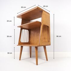 a wooden desk with a wire basket on it's side and measurements for the top shelf