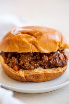 a sloppy joe sandwich sitting on top of a white plate