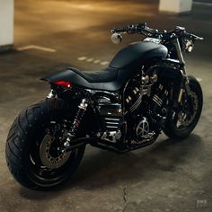 a black motorcycle parked in an empty parking lot with no one around on the bike