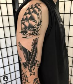 a man's arm with an eagle and ship tattoo on it