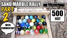 a box filled with marbles next to a sign that says sand marble rally part 2