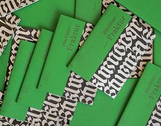 several pieces of green paper sitting on top of a leopard print tablecloth with black and white designs