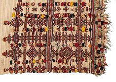 an old rug with many different colors and designs on the edges, including fringes