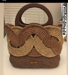 a brown purse sitting on top of a white counter next to a window with blinds