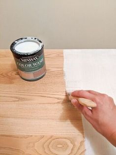 someone using a paint brush to apply wood