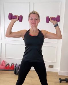 a woman is doing exercises with two dumbbells