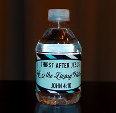 a bottle of water sitting on top of a table next to a glass container with the words, christ after jesus it is the living world john 4 10