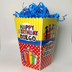 a birthday card box filled with blue streamers and paper cut out characters on it