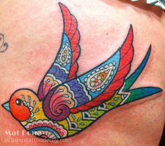 an image of a colorful bird tattoo on someone's back