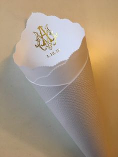 a white paper cone with gold monogrammed initials