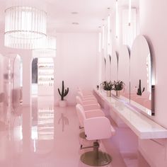 a room with pink chairs and mirrors in it