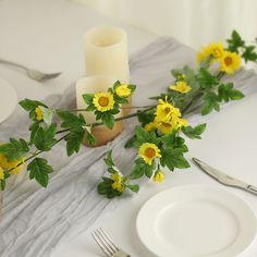 the table is set with yellow flowers and candles