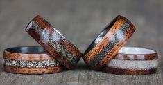 two wooden wedding rings with different colored wood inlays on top of each other