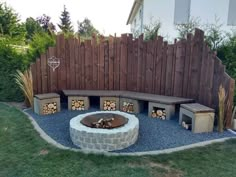 an outdoor fire pit surrounded by wooden fence