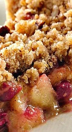 a piece of pie with crumbs and fruit on it sitting on a plate