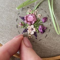 someone is stitching flowers on a piece of fabric